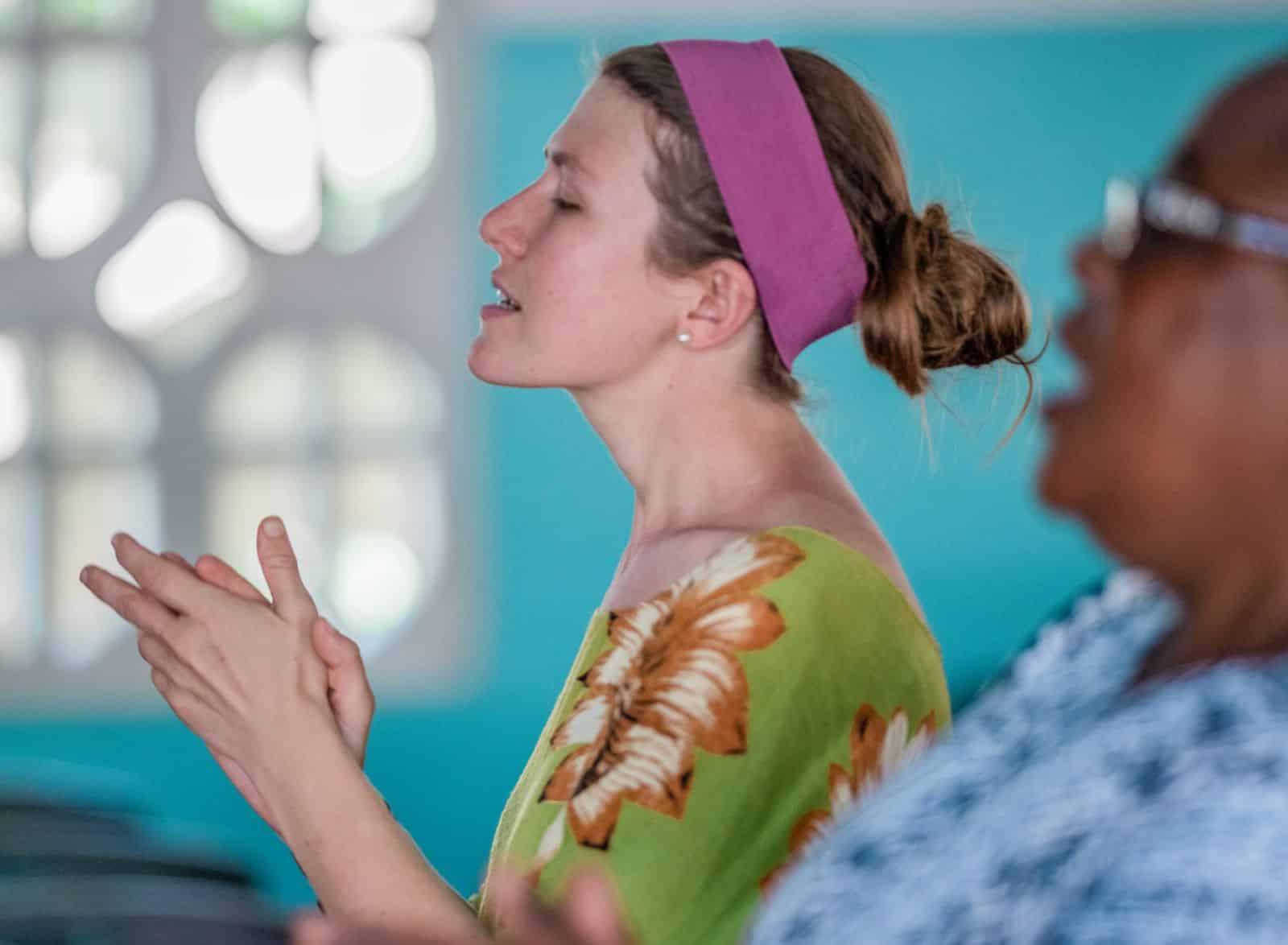 A woman singing as part of a Christian mission service in Africa
